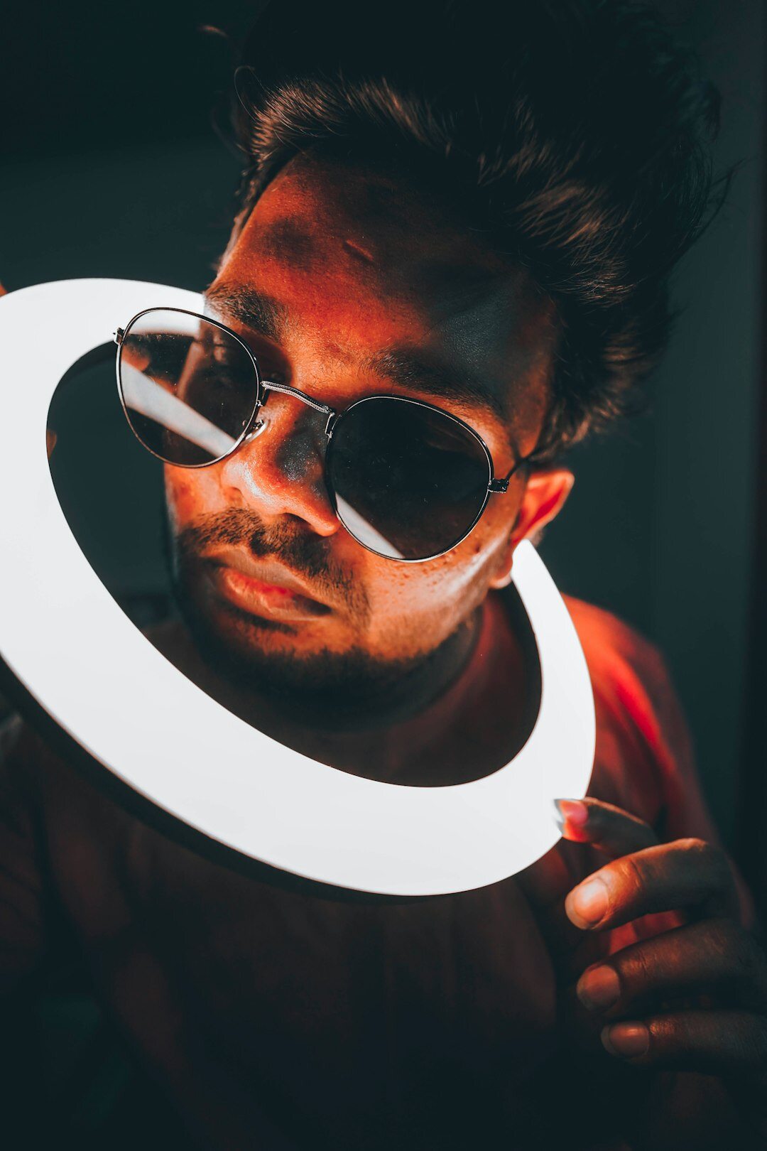 Young influencer recording content with a smartphone and ring light